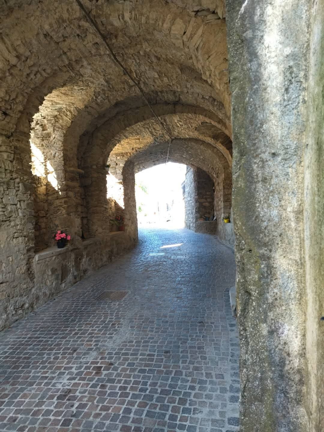 Vicolo coperto ad arcate in pietra nel borgo medievale di Borgofreddo, Calice al Cornoviglio